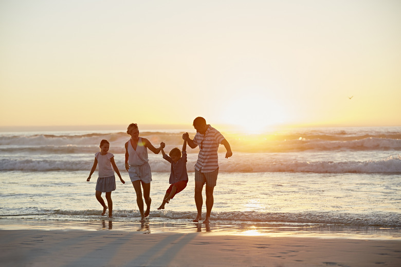 Parents with children enjoying vacation on beach destination